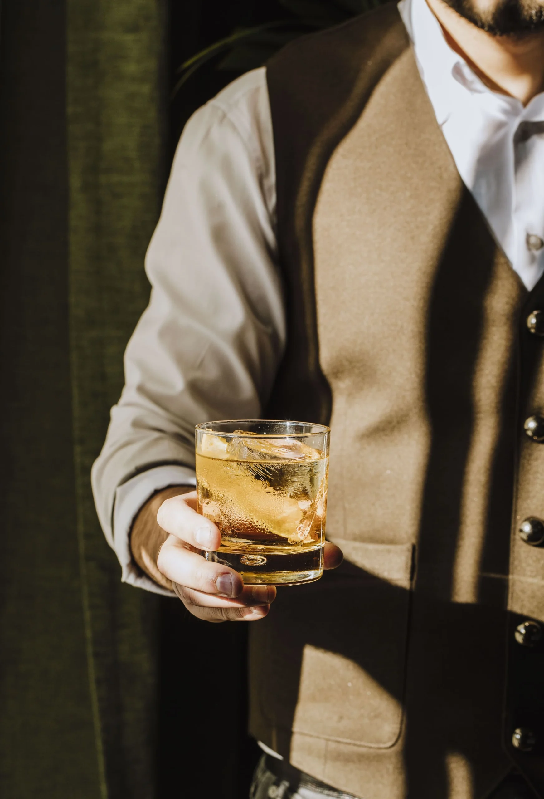 Mann hält einen Old Fashioned in der Hand.