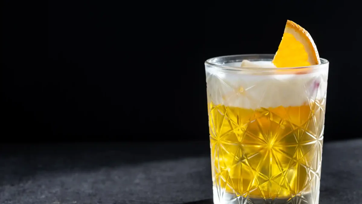 Klassischer Whiskey Sour im Tumbler mit Orangenscheibe und Schaumkrone